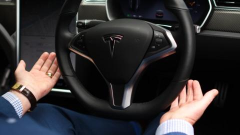 hands off a tesla steering wheel