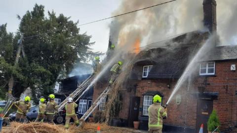Firefighters tackling a blaze at the Axe and Compasses pub