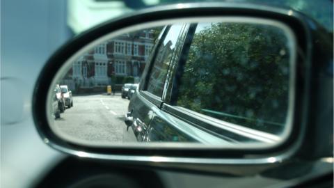 Reflection of the road in car wing mirror