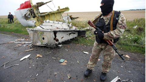 A pro-Russian separatist stands at the crash site of Malaysia Airlines flight MH17