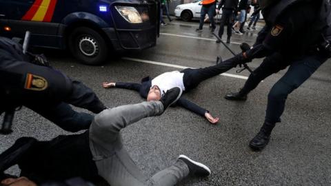 Spanish Civil Guard officers remove demonstrators outside a polling station for the banned independence referendum in Barcelona, Spain, October 1, 2017