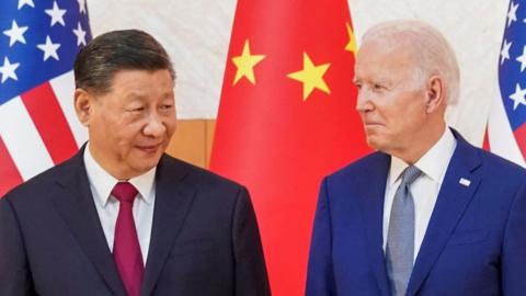 Xi Jinping and Joe Biden stand in front of US and Chinese flags at the G20 summit