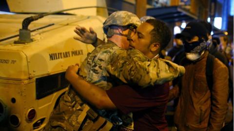 A US National Guard soldier accepts a hug from a protestor on the third night of protests in Charlotte, North Carolina