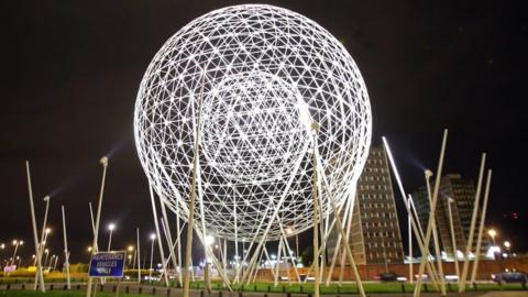 Spherical metal sculpture at night