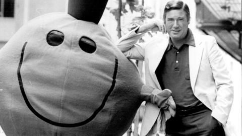A black and white image of Roger Hargreaves standing next to Mr Tickle.