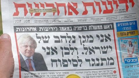 A man looks at an article by Boris Johnson on the front page of the Hebrew-language Israeli newspaper Yedioth Ahronoth (1 July 2020)