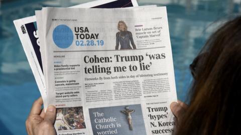 A woman reading USA Today