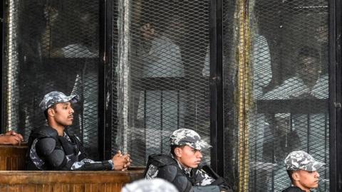 Members of Egypt"s banned Muslim Brotherhood are seen inside a glass dock during their trial in the capital Cairo on July 28, 2018.