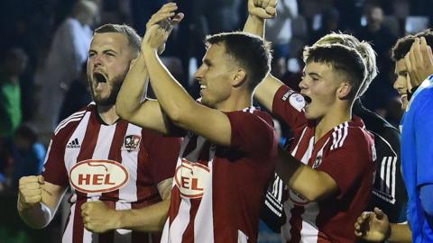 Exeter players celebrate progressing in the Carabao Cup