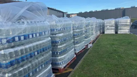 A large number of water bottles on crates