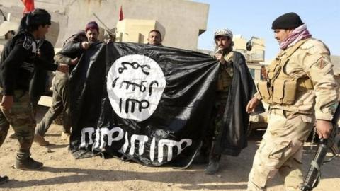 Iraqi soldiers hold IS flag captured in village outside Mosul (29/11/16)