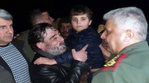 Screengrab of video from Syria's Sana news agency showing Fawwaz al-Qataifan being carried by his father after kidnappers released the boy on 12 February 2022