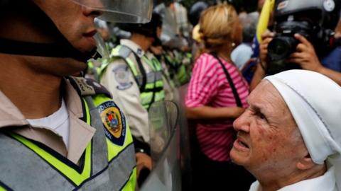 Elderly woman faces police in Caracas march