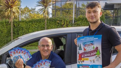 Bill Cann and Callum Le Lacheur from Guernsey Post’s Lottery team with the new 2023 Christmas tickets