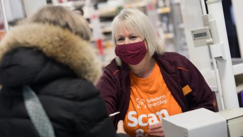 Sainsbury's worker on a till