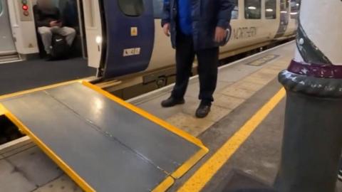 A bollard in front of a ramp leading up to a train