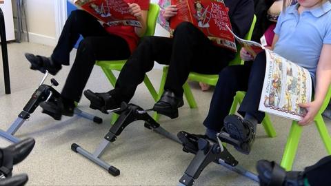Pupils using pedal machines while reading