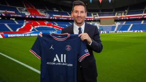 Lionel Messi posing with his PSG shirt