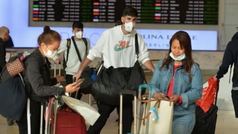 Travellers wearing surgical masks at an airport
