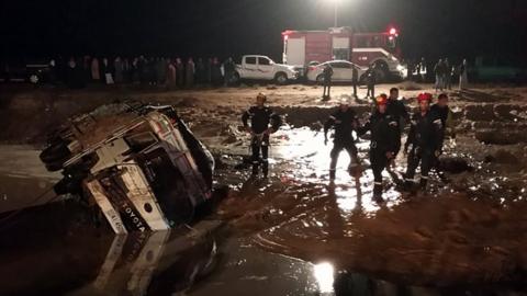 Jordanian civil protection services work on a road that was damaged by flash floods near Madaba, south of Amman, 9 November 2018