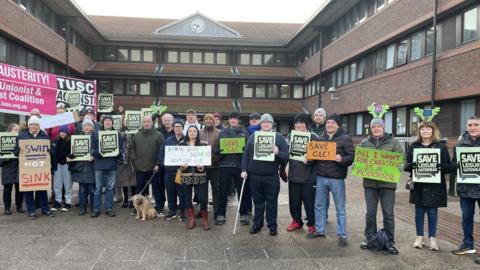 People outside Gateshead Council with signs