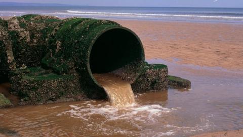 An outlet pipe discharging sewage onto a North sea beach