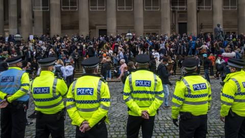 police officers watch demonstrators