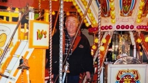 Roger Austin standing in the middle of a fairground ride