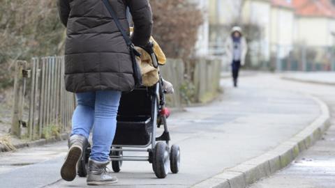 Woman pushing pushchair