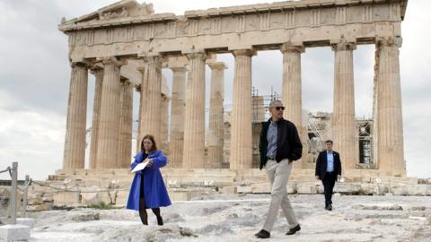 US President Barack Obama (R) walks in front of the Parthenon during a tour of the Acropolis on November 16, 2016 in Athens, Greece