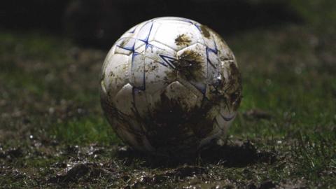 A football is caked in mud