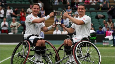Alfie Hewett and Gordon Reid hold the Wimbledon men's doubles trophy in 2023