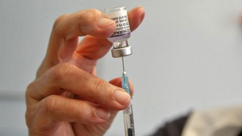 A health worker prepares to administer a dose of Pfizer/BioNTech Covid-19 vaccine