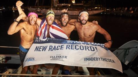 Four rowers celebrating