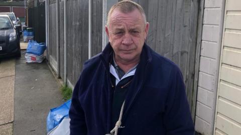 Man standing on pavement in Essex