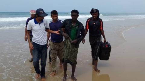 IOM Yemen officials assist a survivor from the capsized boat