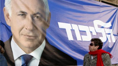 Israeli woman walks past election campaign poster of Benjamin Netanyahu (file photo)