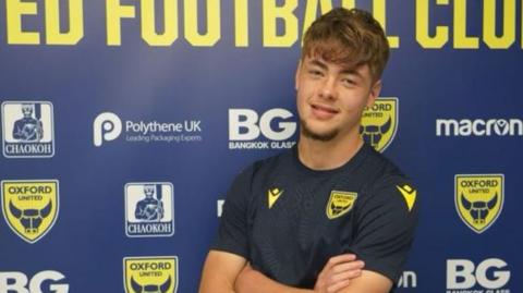 Striker Cameron Cooper poses in his training shirt at Oxford United's training facility.