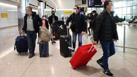 Masked passengers arriving at Heathrow