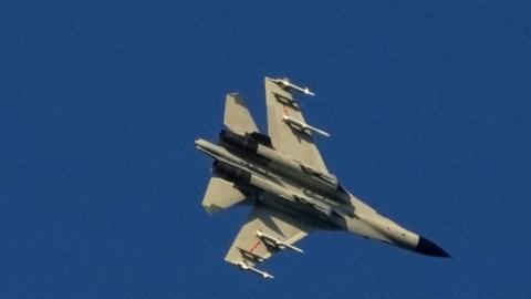 A Chinese People's Liberation Army (PLA) aircraft flies over the 68-nautical-mile scenic spot, one of mainland China's closest points to the island of Taiwan, in Pingtan island, China