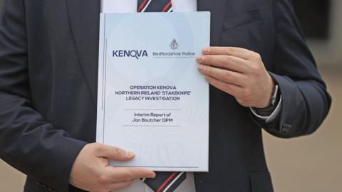 Picture of someone holding up the Kenova report