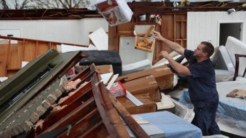 A man salvages what he can from his store in Lake Charles