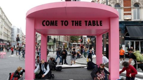 Extinction Rebellion protesters building a pink table