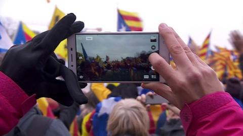 Person takes photograph using phone of Catalan protesters