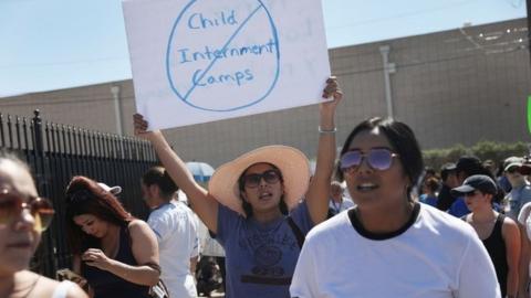 A protester holds up a banner saying 'No child internment camps' outside an immigration detention centre in El Paso, Texas, 19 June 2018