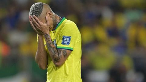 Richarlison playing for Brazil with his head in his hands