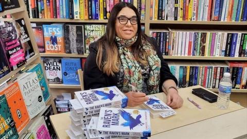 Christie Newport signs copies of her book in a bookshop