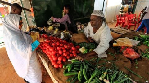 A Sudanese woman buys vegetables at the Al-Khaimah market in Khartoum
