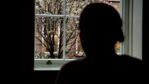 'Amy', an anonymised woman photographed in silhouette with a blossom tree in the background
