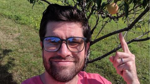 Rhys O'Neill with the peach tree he bought for his wife on their first date